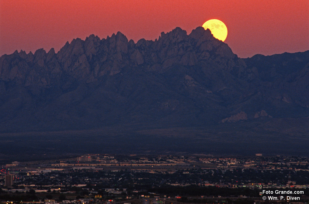 The moon rises at sunset over the Organ Mountains and Las Cruces, N.M. © William P. Diven